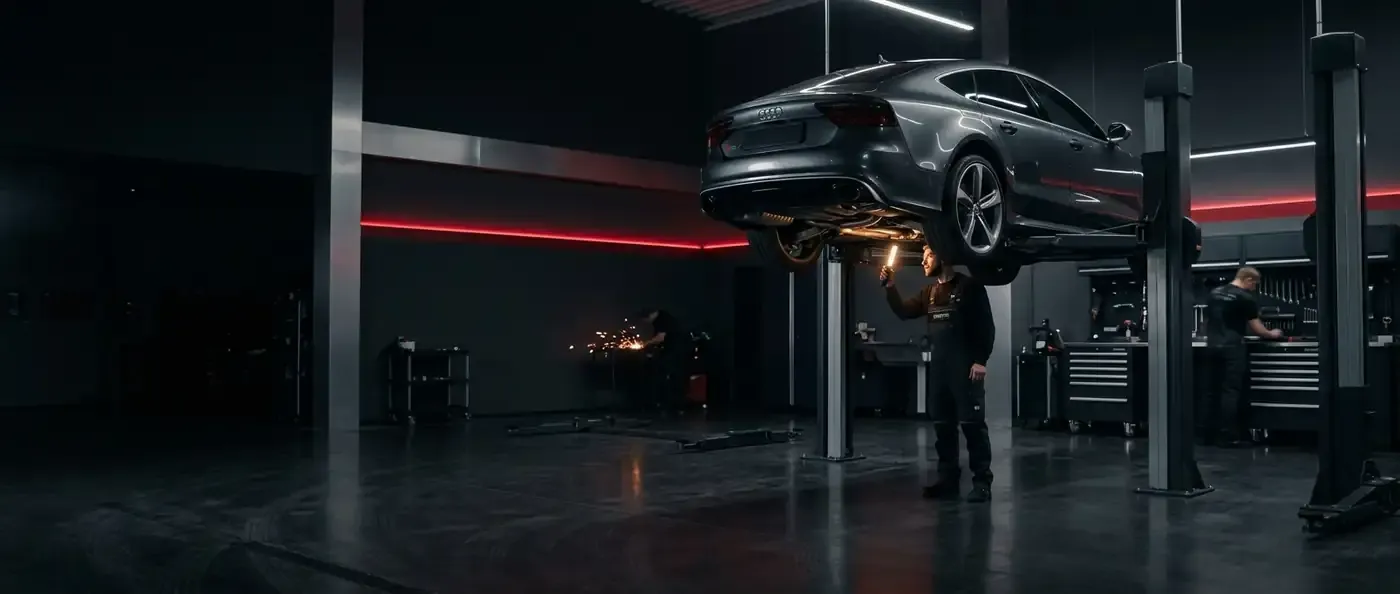 JSIR Auto Maintenance workshop — a car raised on a two-post lift